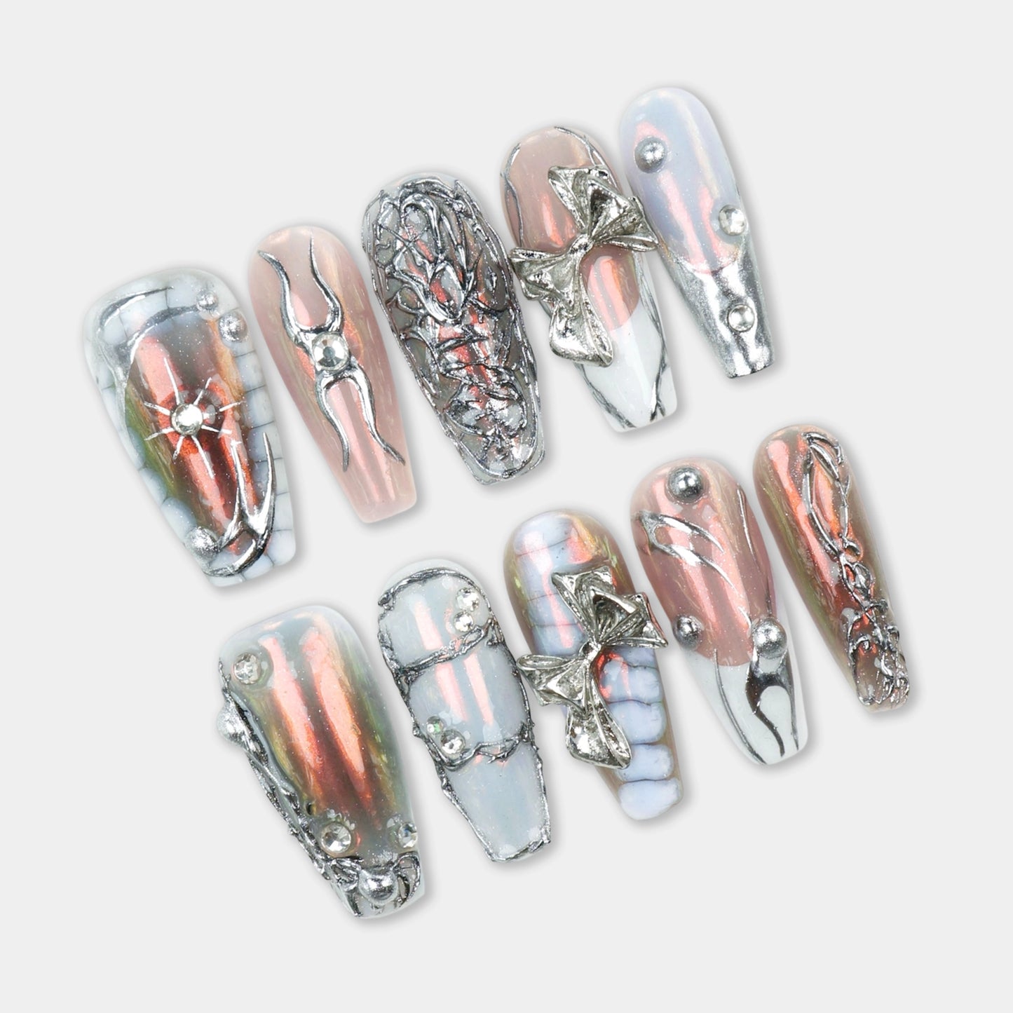 Press-on nails with a blend of chrome pink, silver accents, and 3D metallic embellishments, including bows and geometric detailing.