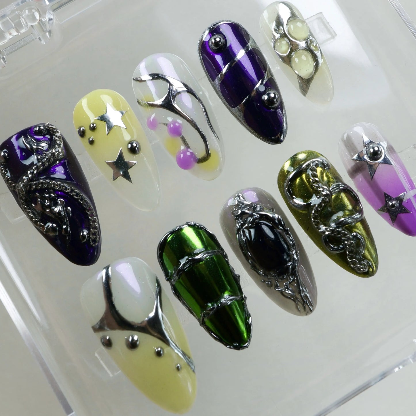 Like a sci-fi rave on your fingertips—chrome claws with stars, alien blobs, and candy-like beads.