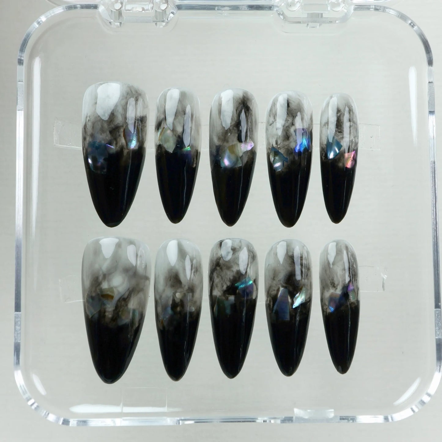 Black marble press-on nails featuring smokey ombré design and holographic foil accents.