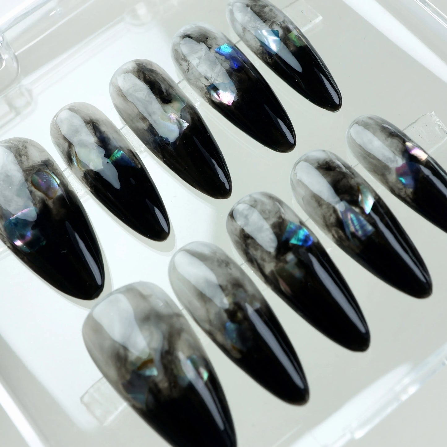 Black marble press-on nails featuring smokey ombré design and holographic foil accents.