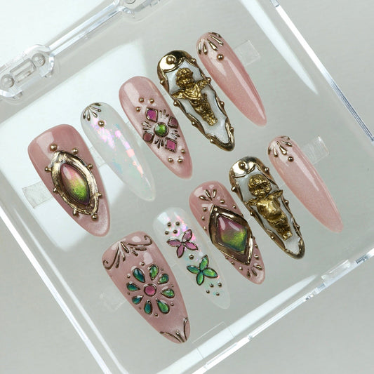 Luxury press-on nails with 3D gold cherubs, opal-like shimmer, gemstone inlays, and colorful butterfly and flower designs.