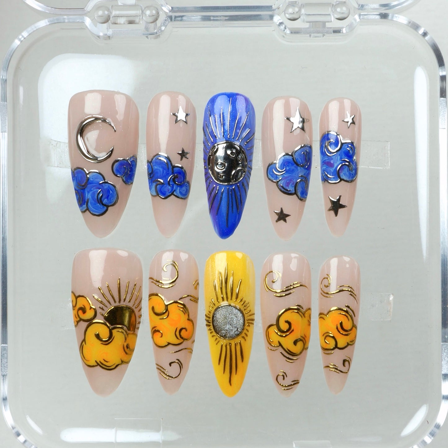 Ethereal nails that blend dreamy sky motifs—silver moons, radiant suns, and swirling clouds on a neutral backdrop.