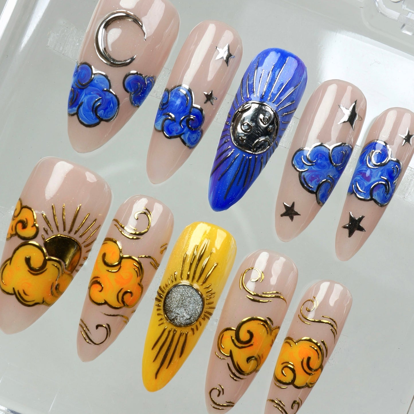 A magical sunrise-to-moonlight nail set with sculpted clouds and cosmic vibes in gold, blue, and nude tones.