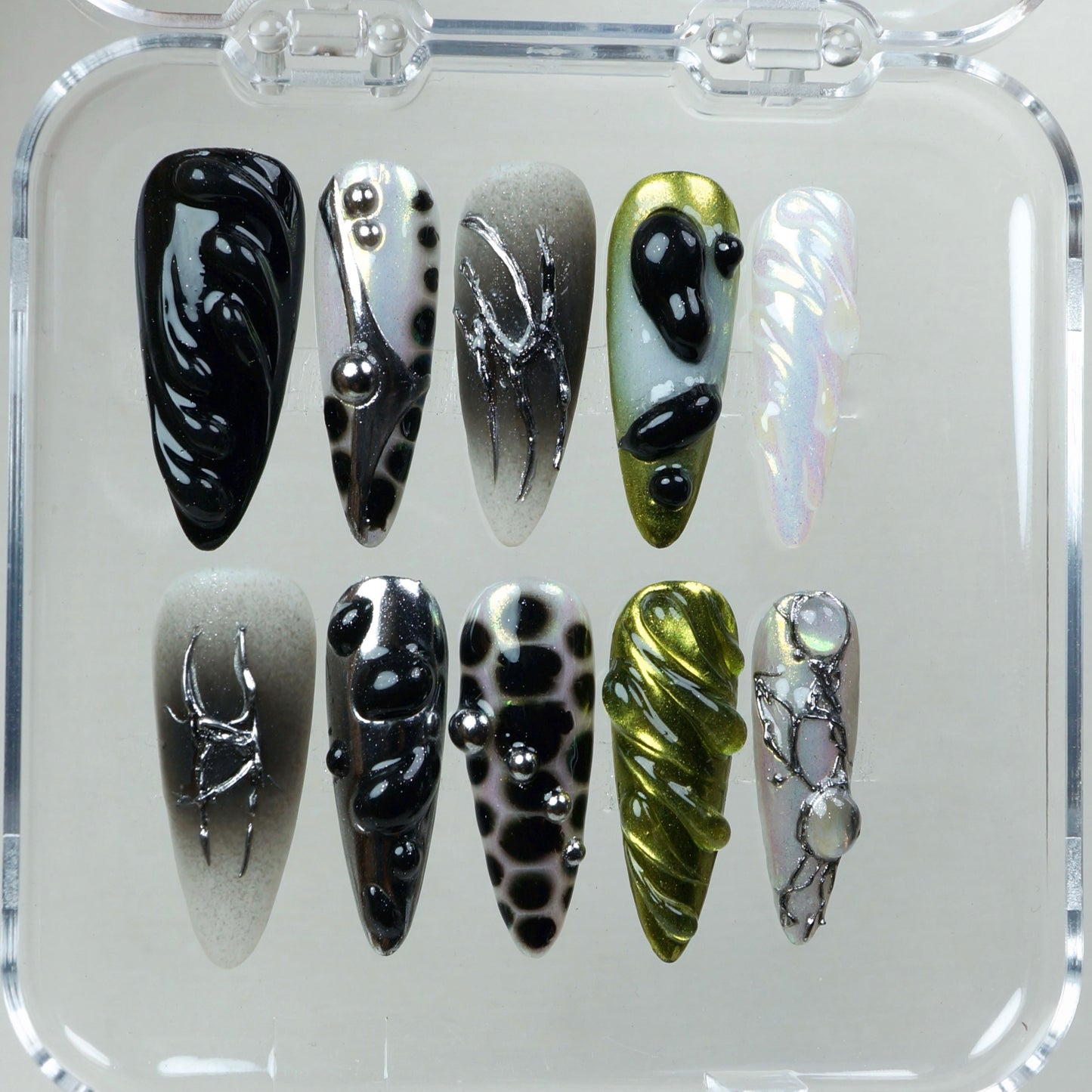 A high-concept nail set combining iridescent finishes, surreal textures, and sculptural chrome accents.
