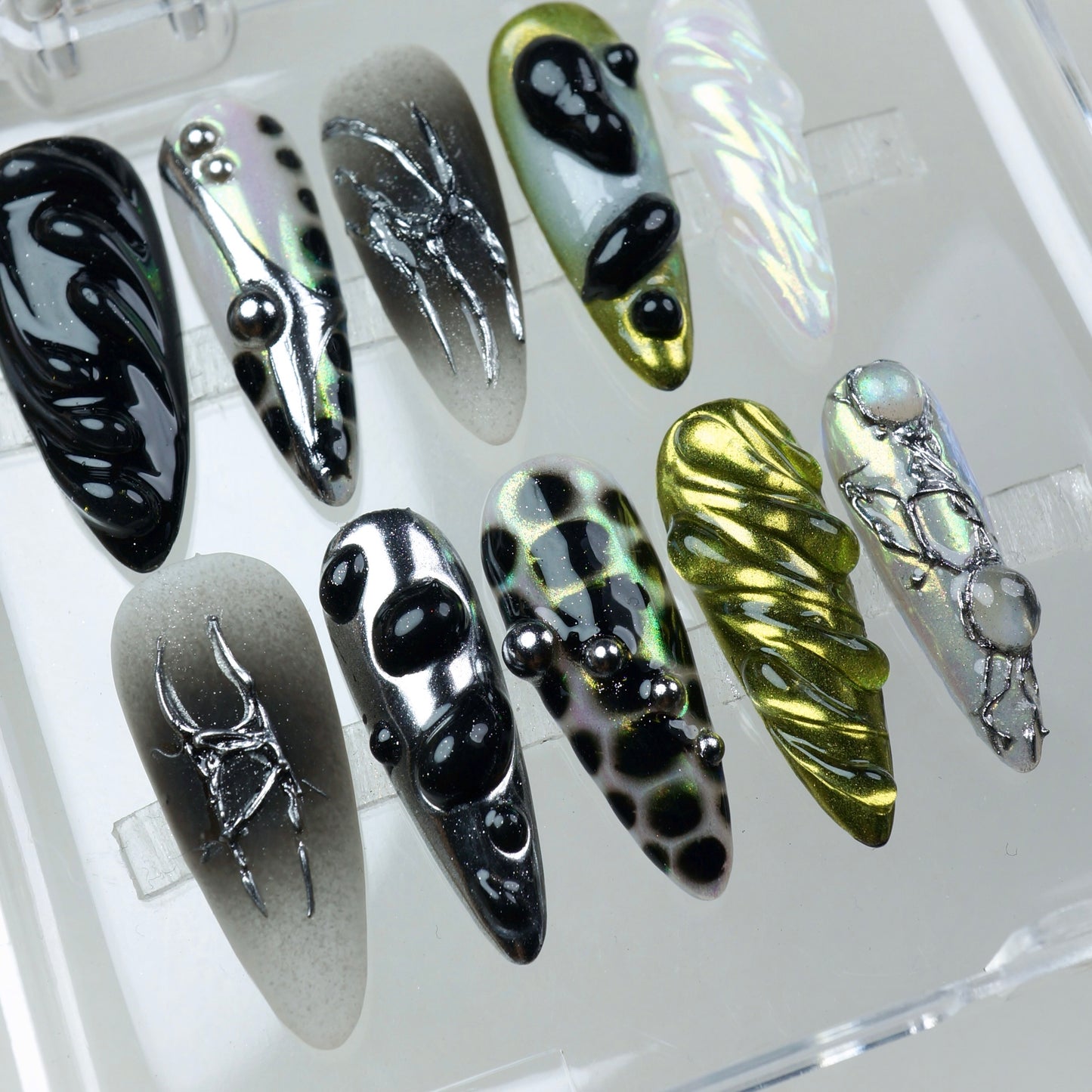 Aliencore-inspired press-on nails with slime-like blobs, reflective chrome, and Y2K metallic vibes.