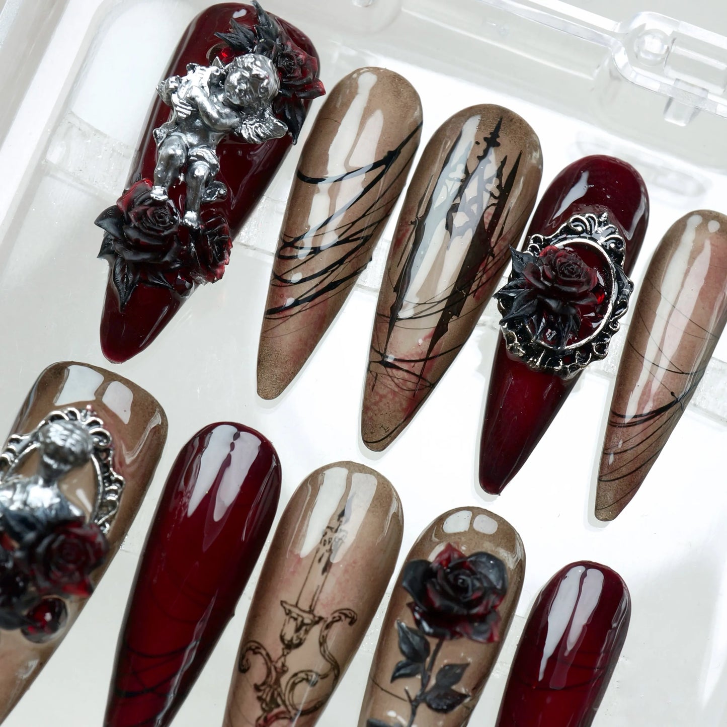 A dramatic gothic nails design with blood-red tips, black roses, and antique-style detailing by Donailsart.