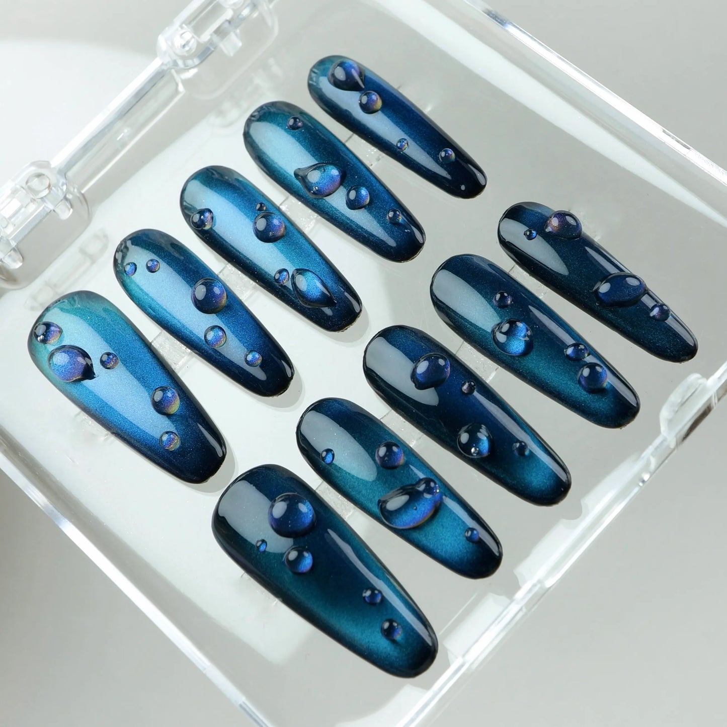 Oceanic blue cat eye gel press-on nails from Donailsart, enhanced with glossy 3D water drops