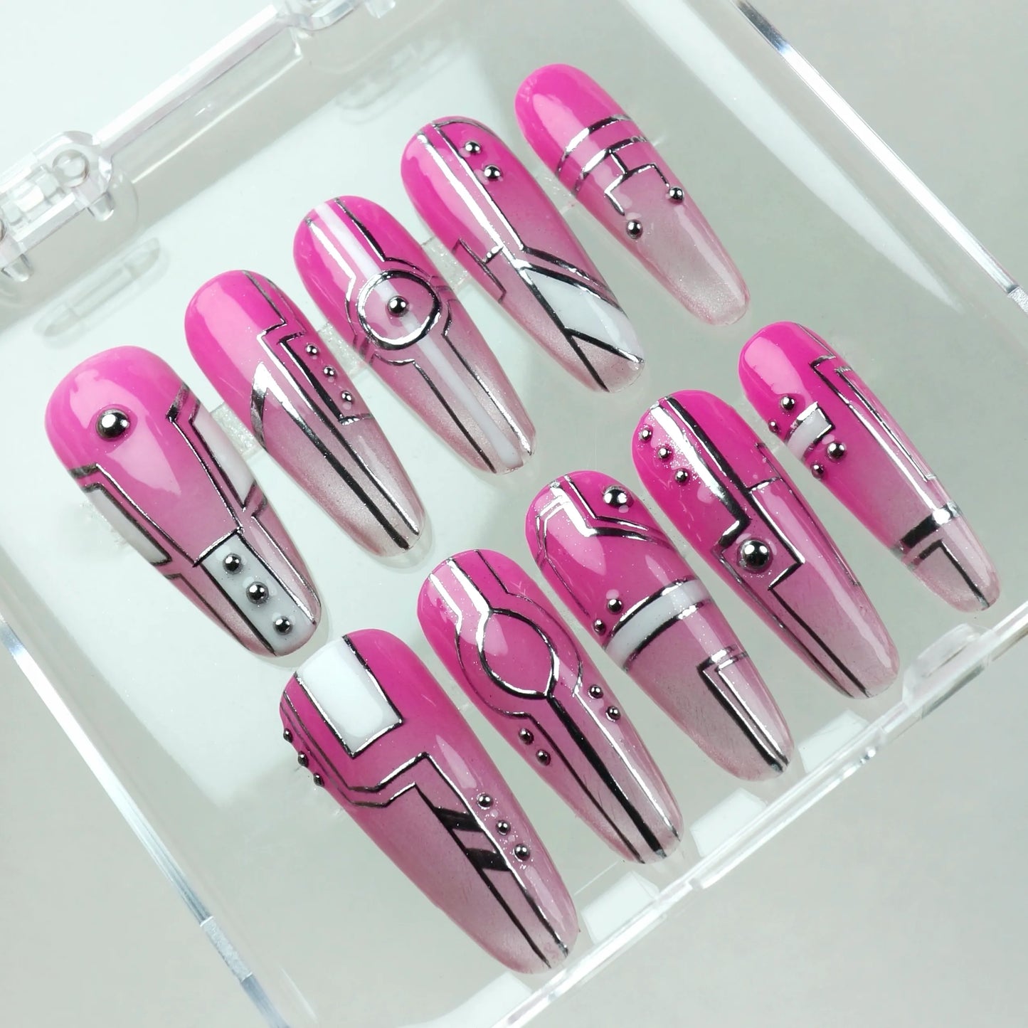Futuristic press-on nails from Donailsart in bold pink tones with silver circuit-style designs and robotic detailing