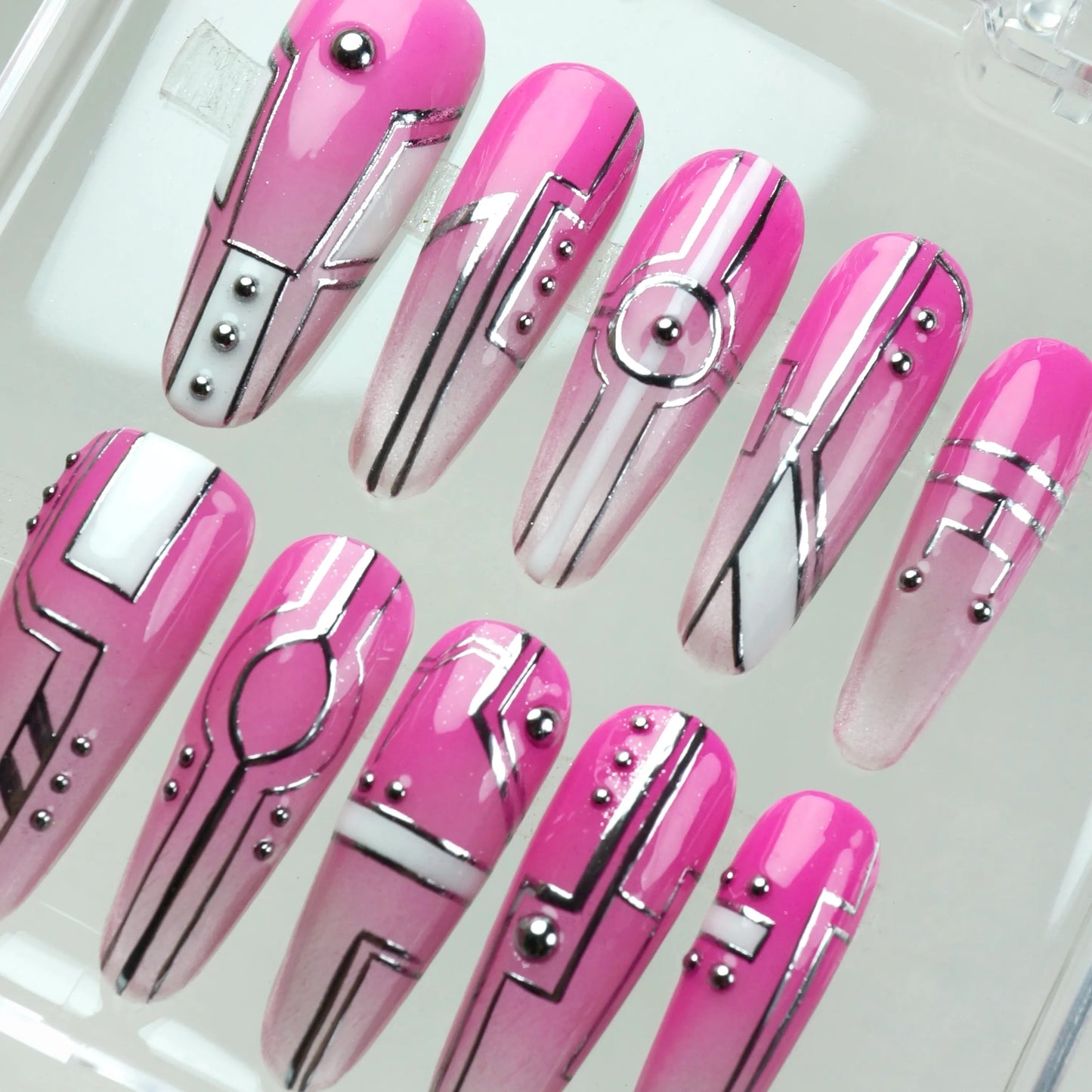 Edgy press-on nails with neon pink gradient, clean silver graphics, and futuristic layout elements
