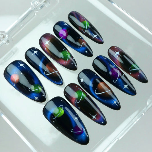 Press-on nails from Donailsart featuring vibrant planets with rings, cosmic gradients, and starry night skies