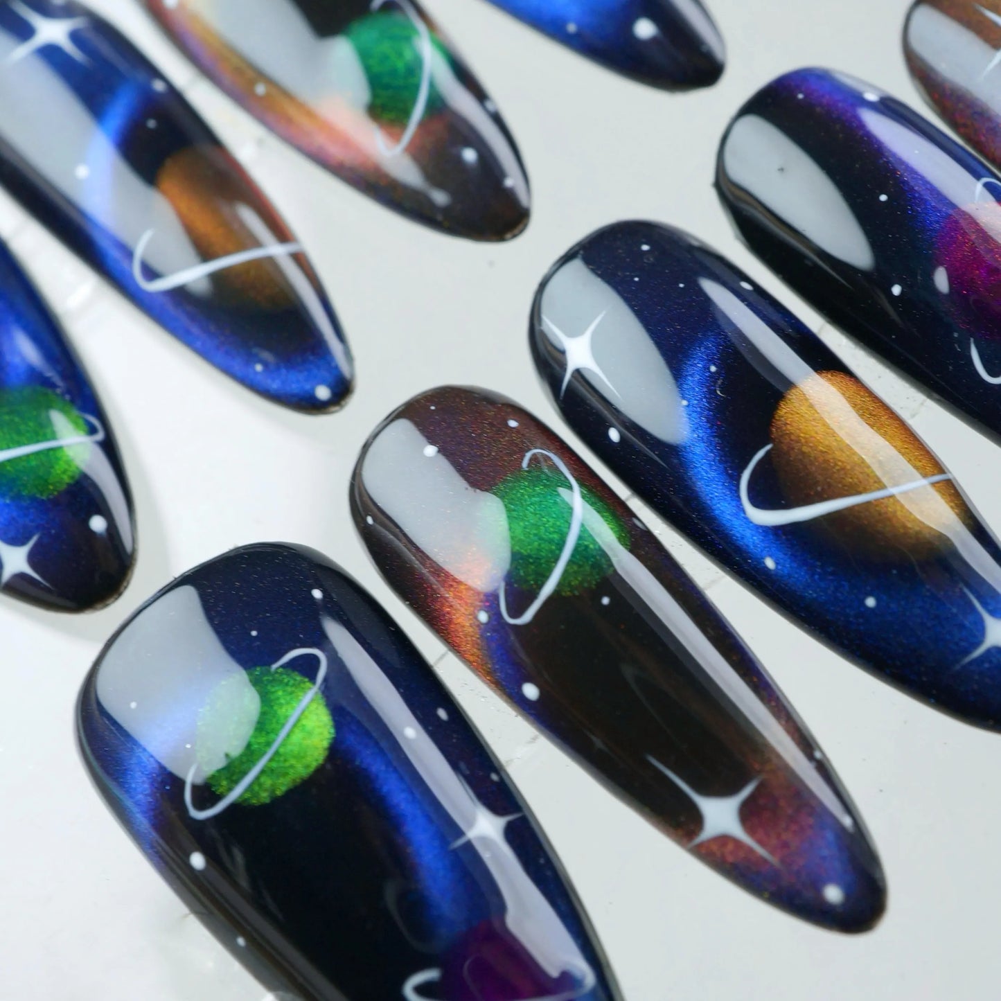 Donailsart press-on nails with glowing planets, orbit rings, and galaxy-inspired shimmer