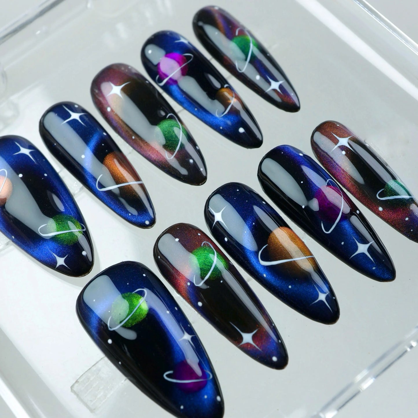 Press-on nails with hand-drawn planets, nebula hues, and a magical galaxy finish, perfect for celestial lovers