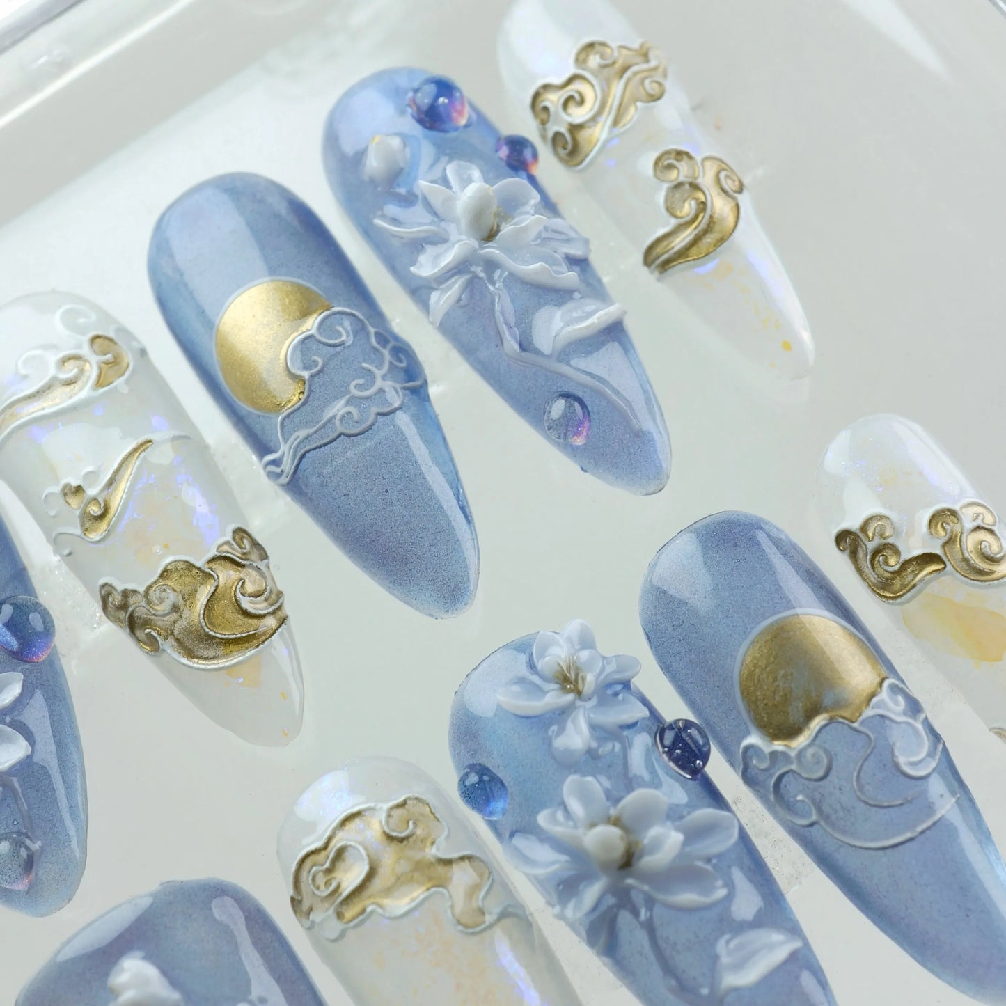 Donailsart press-on nails with floral accents, gold moon motifs, and iridescent soft tones