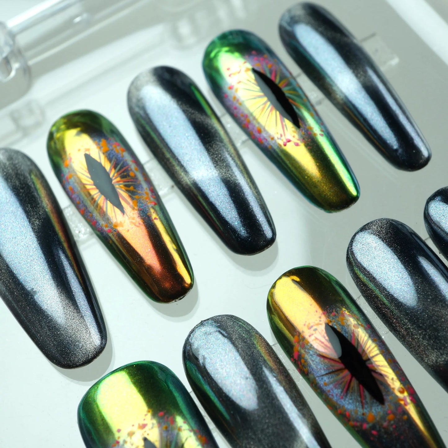 Galactic press-on nails featuring reflective dragon-eye details and magnetic black cat-eye finishes