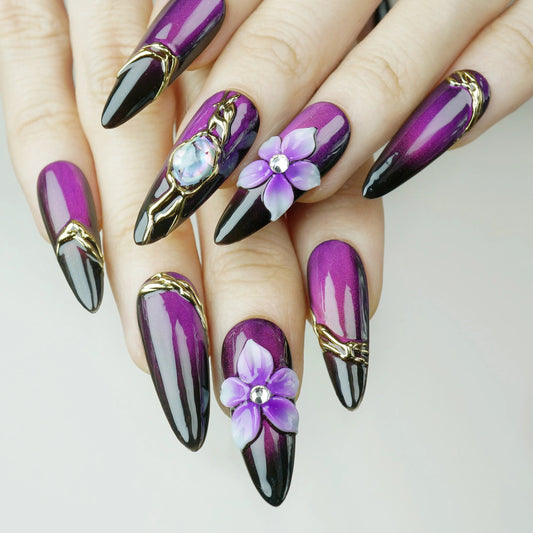 Purple and black nail art with floral designs on a neutral background