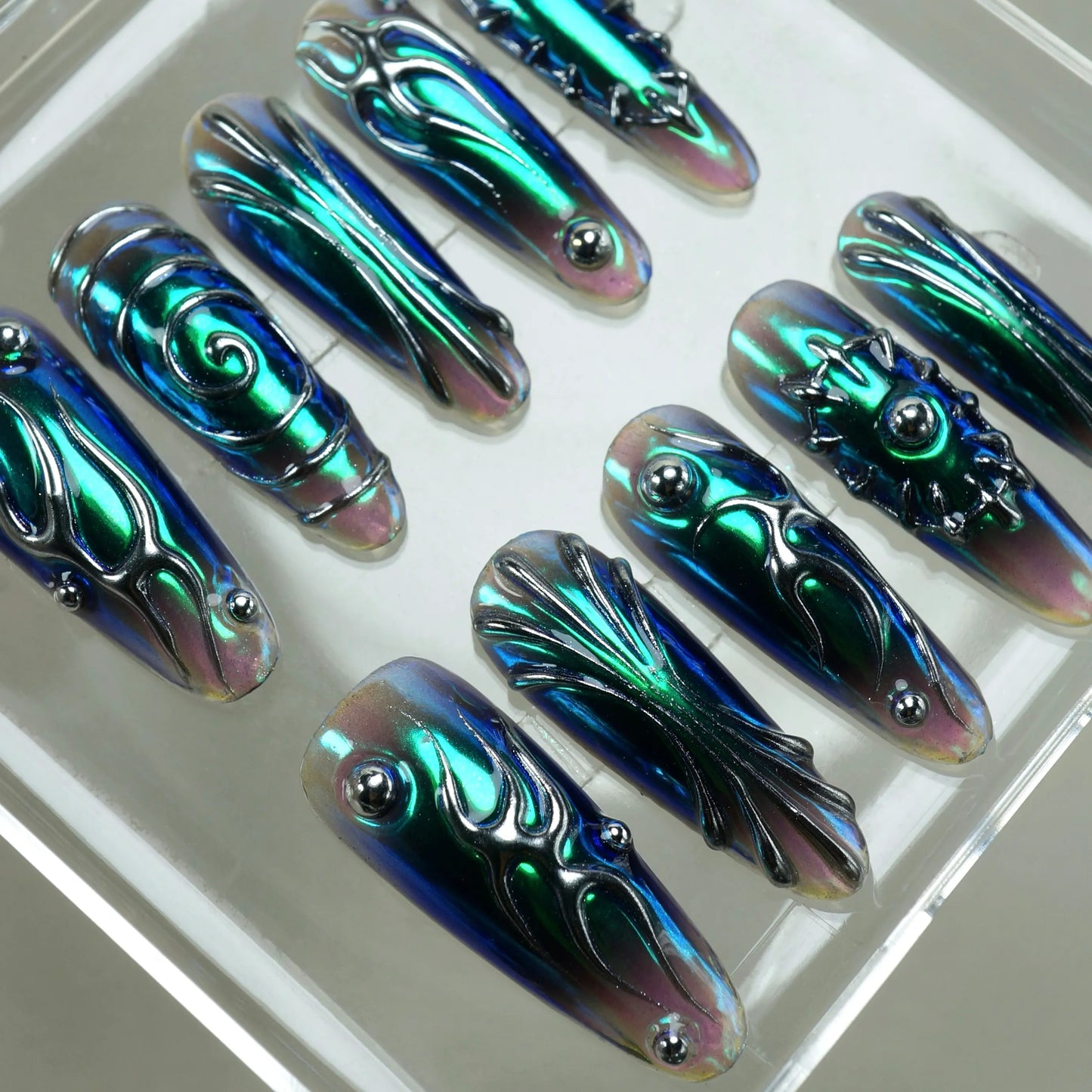 Iridescent nail art designs on a white tray