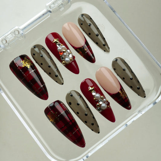 Holiday plaid nail set featuring deep red tartan, sheer polka dot tips, and pearl Christmas tree embellishments Donailsart