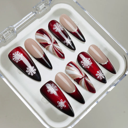 Glossy red gradient Christmas nails featuring white snowflakes and metallic swirl patterns Donailsart
