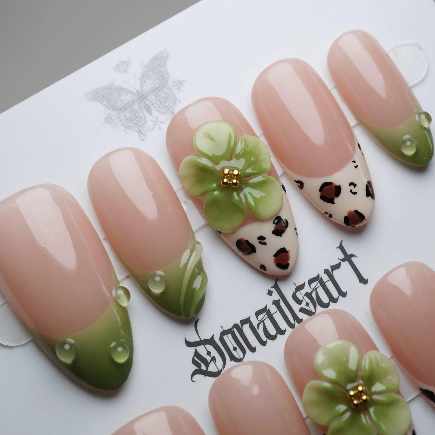 B7 | Palm Kiss press-on nail set product view with soft sunlit nude, green tips, and floral nail art by Donailsart