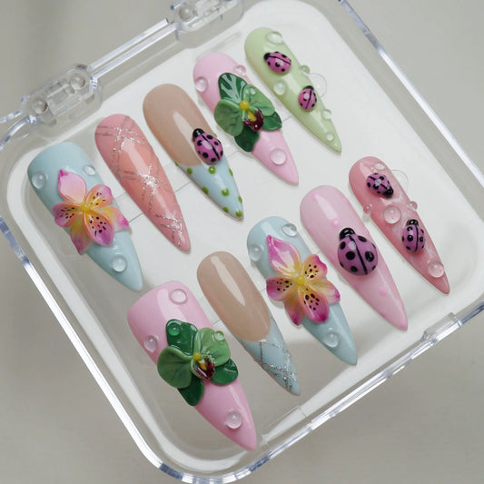 Ladybug Lagoon press-on nails on display showing the full pastel garden nail art collection in pink, mint, and blue – Donailsart