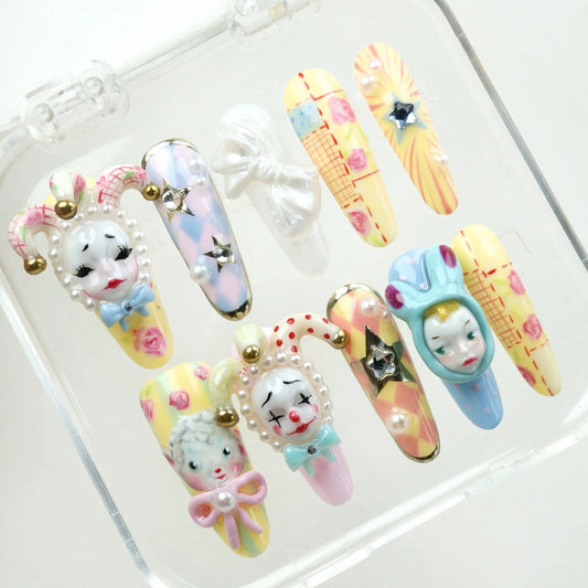 Pastel Carnival press-on nails displayed in clear packaging tray showing the complete set with pastel colors and 3D clown character details – Donailsart