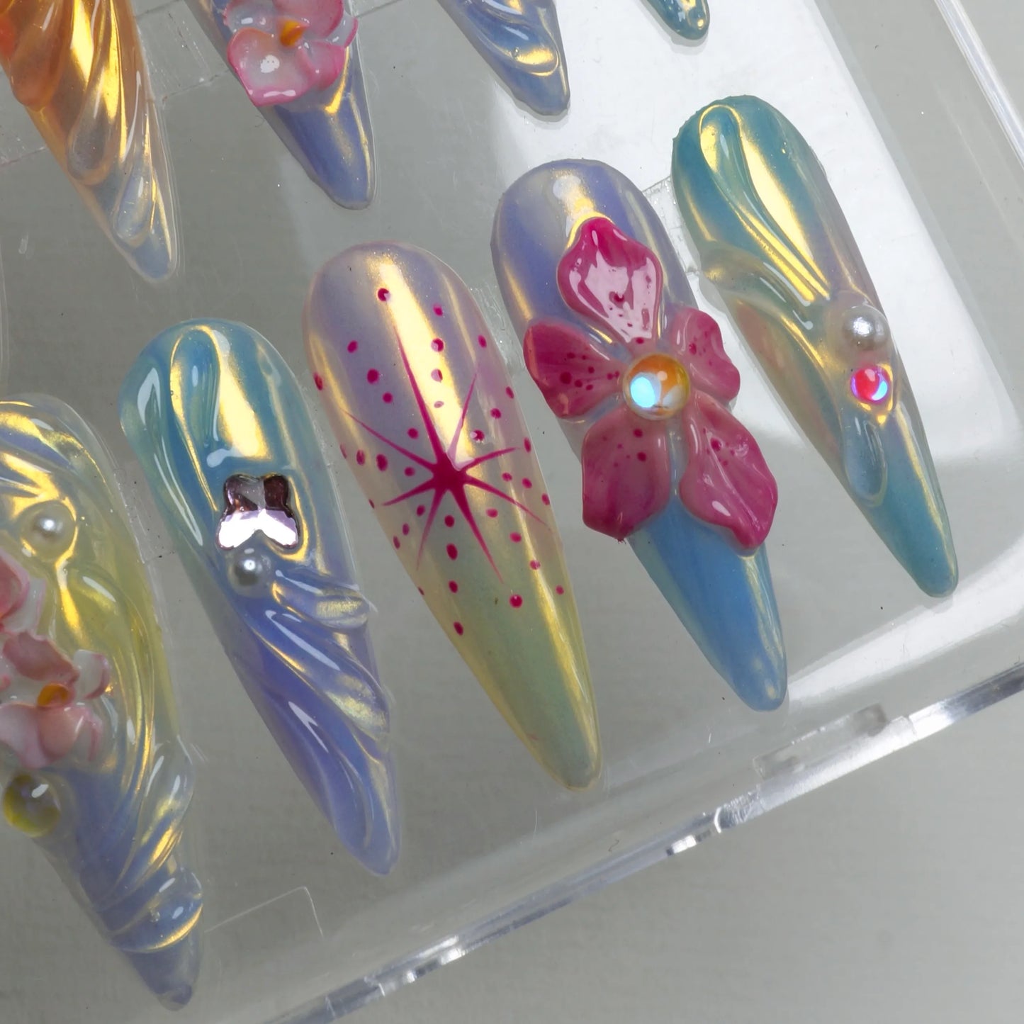 Summer flower nails from Donailsart with glossy chrome sheen, pink floral designs, and pearlescent colors
