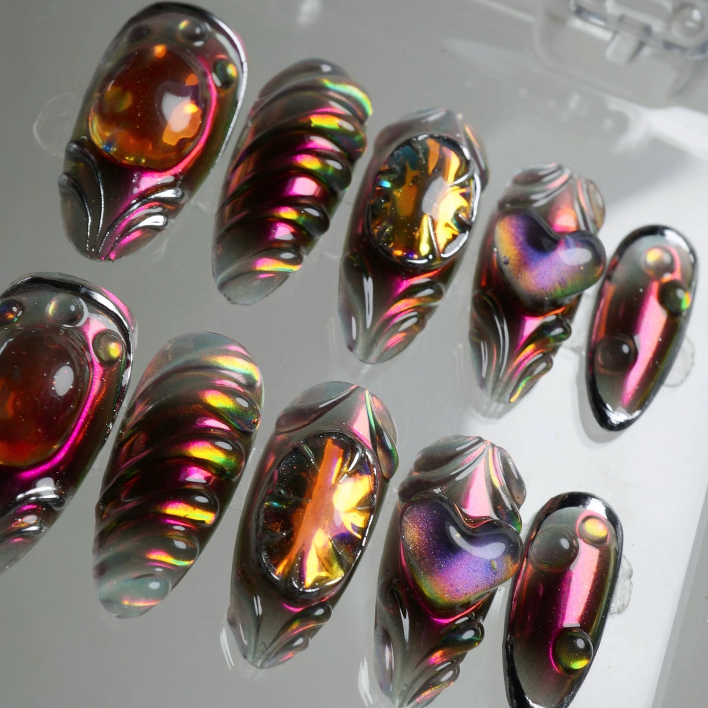 Press-on nails by Donailsart featuring molten glass-like effects, chrome edges, and sculpted flames in deep purple and orange tones