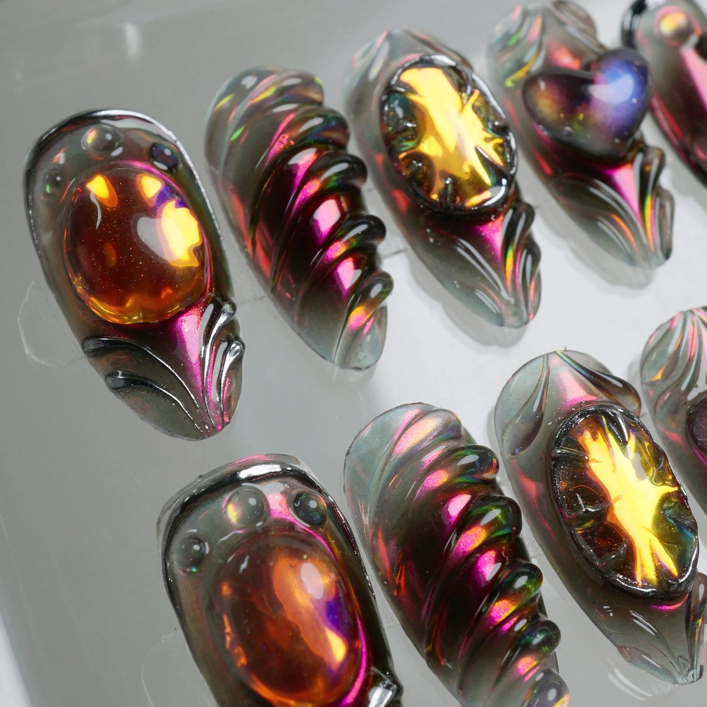Press-on nails by Donailsart featuring molten glass-like effects, chrome edges, and sculpted flames in deep purple and orange tones