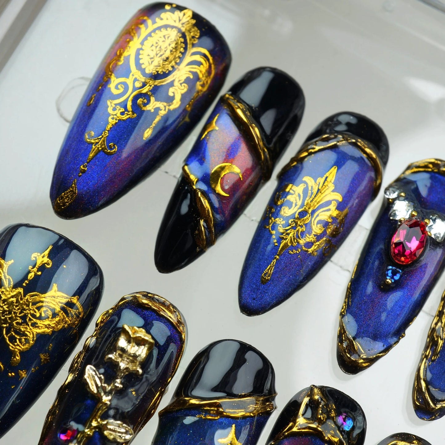 Baroque press-on nails from Donailsart with rich navy tones, moon phases, and intricate gold embellishments