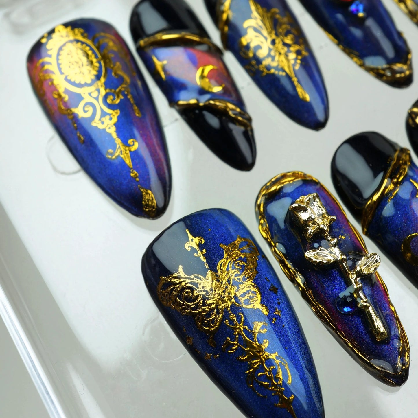 Baroque press-on nails from Donailsart with rich navy tones, moon phases, and intricate gold embellishments