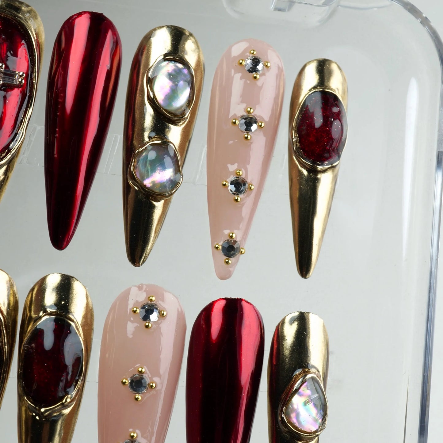 Donailsart press-on nails with red chrome, gold metal framing, and crystal cross accents