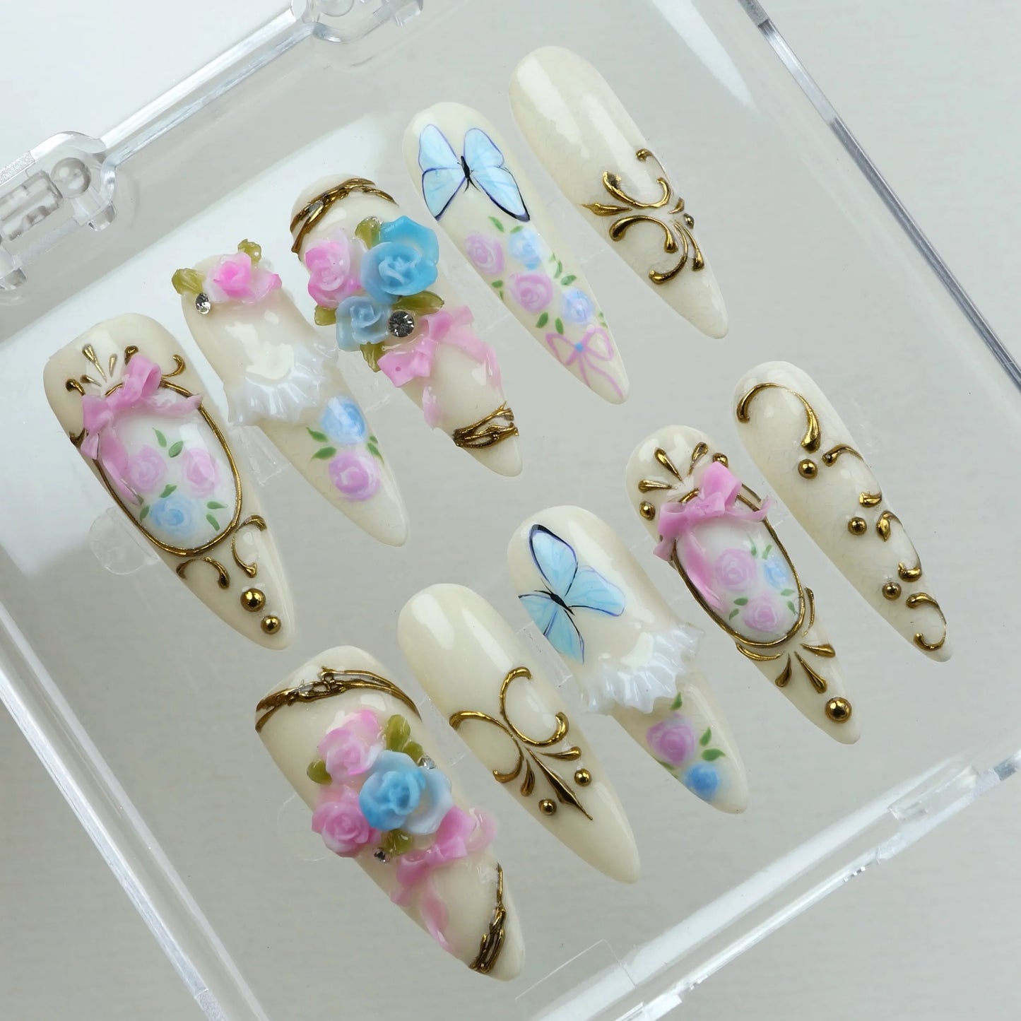 Whimsical birthday nails with 3D florals, delicate lace details, and vintage-inspired gold accents
