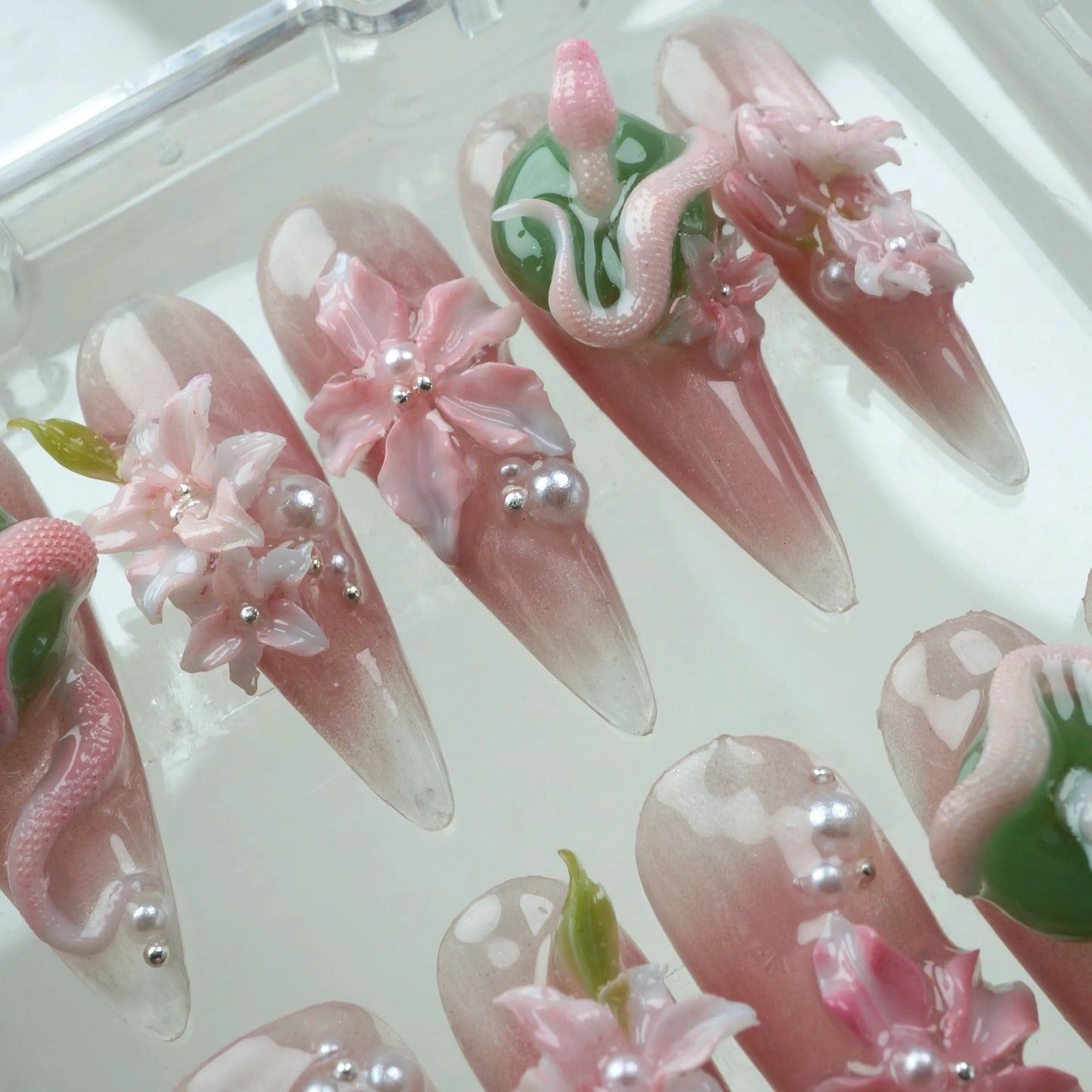 Bold flower design nails with nature-inspired textures, blending pink florals and green serpent elements