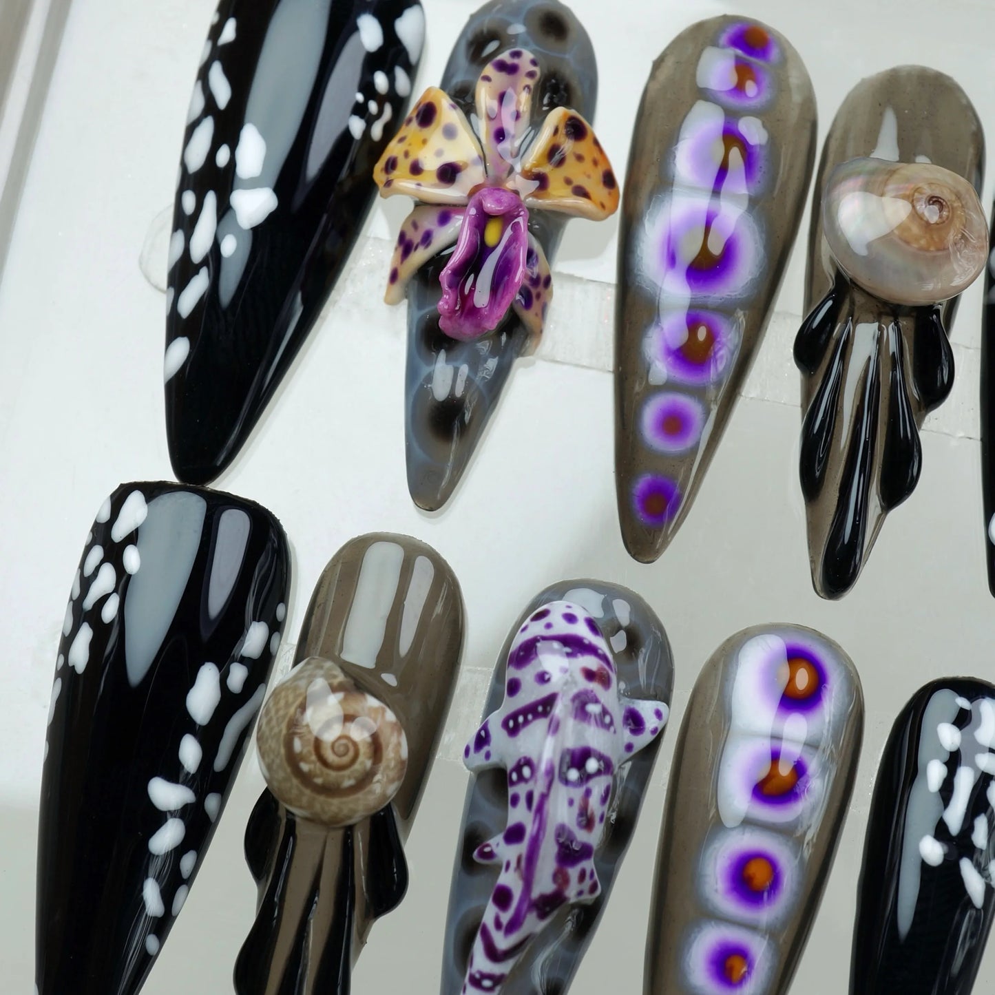 Underwater fantasy summer nails with intricate marine life designs and contrasting black and white spotted tips.