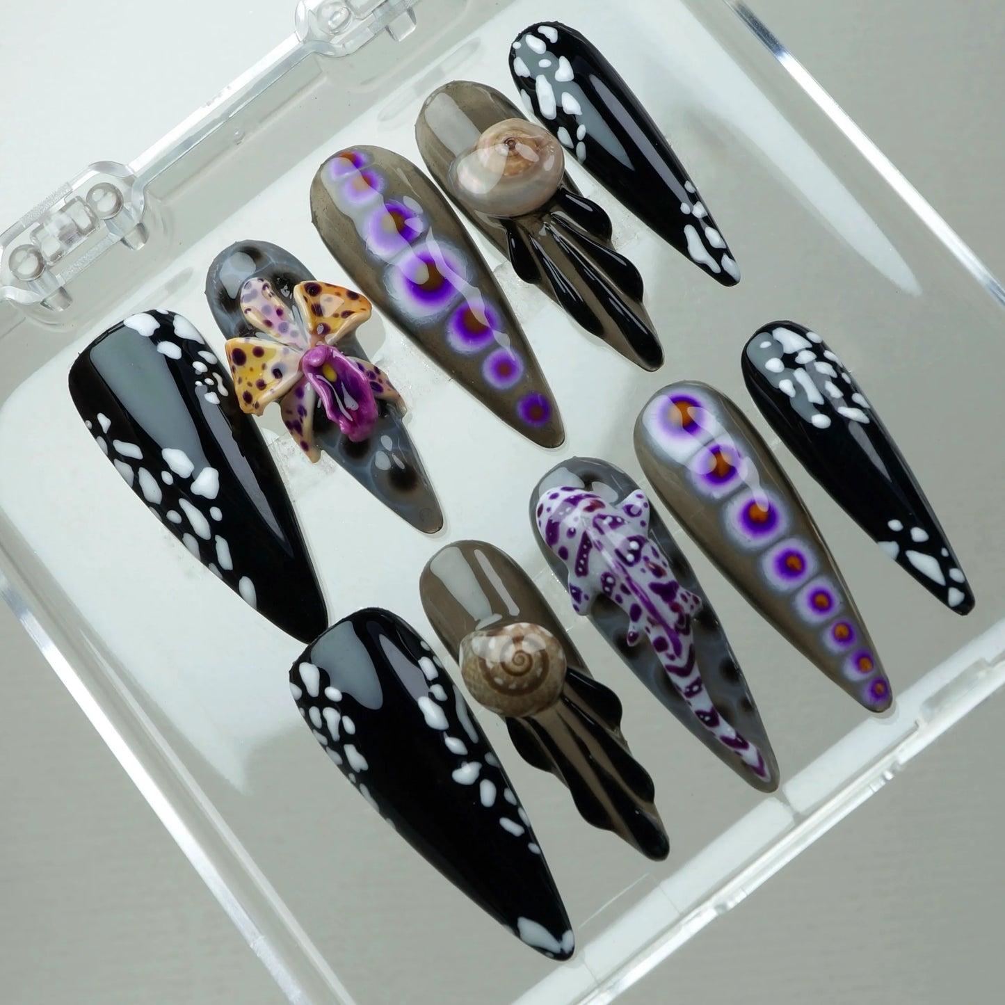 Unique summer nails with oceanic details like sea slugs and spotted black designs, perfect for adventurous beach lovers.