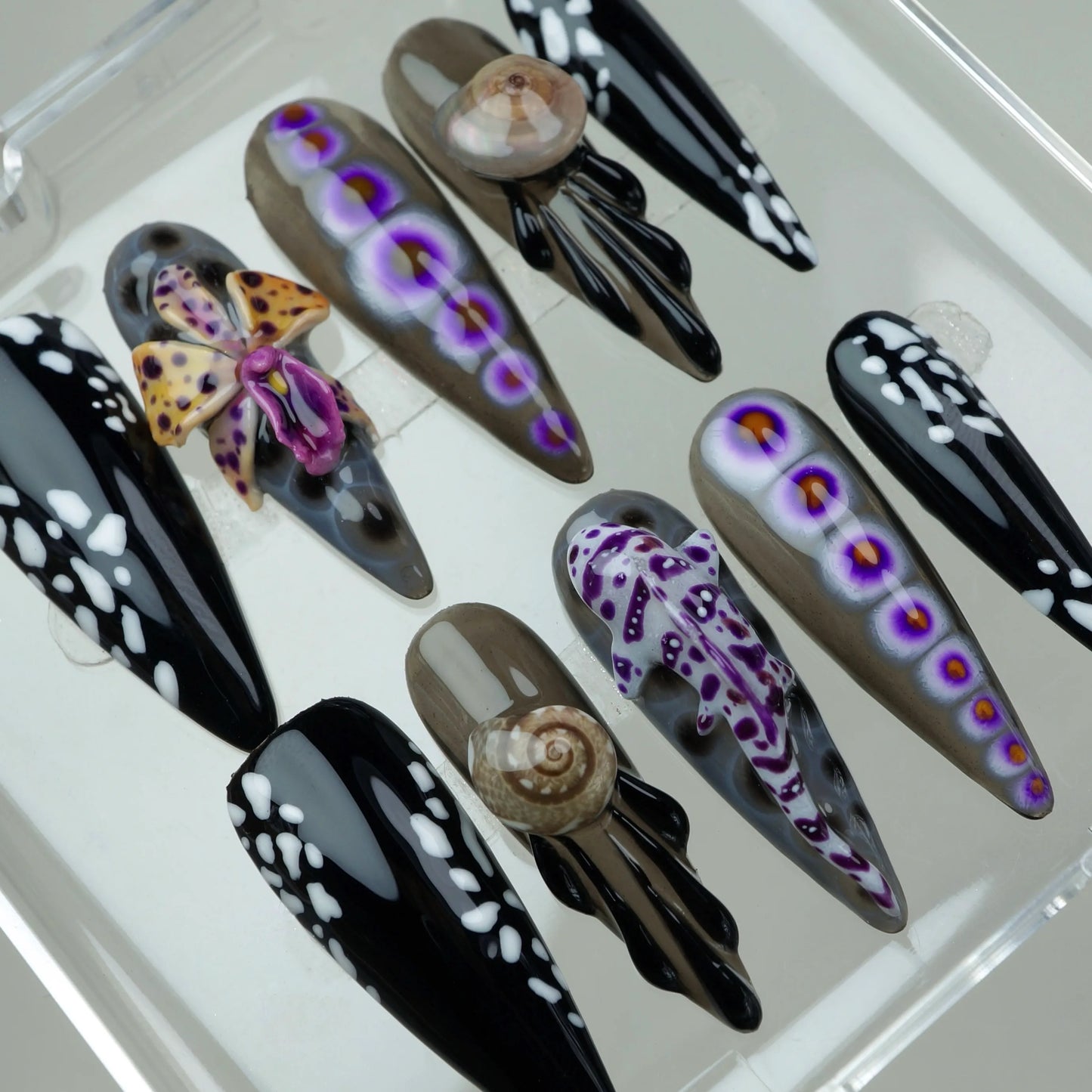 Edgy summer nails featuring sea life motifs, purple accents, and dramatic black-and-white contrast designs.