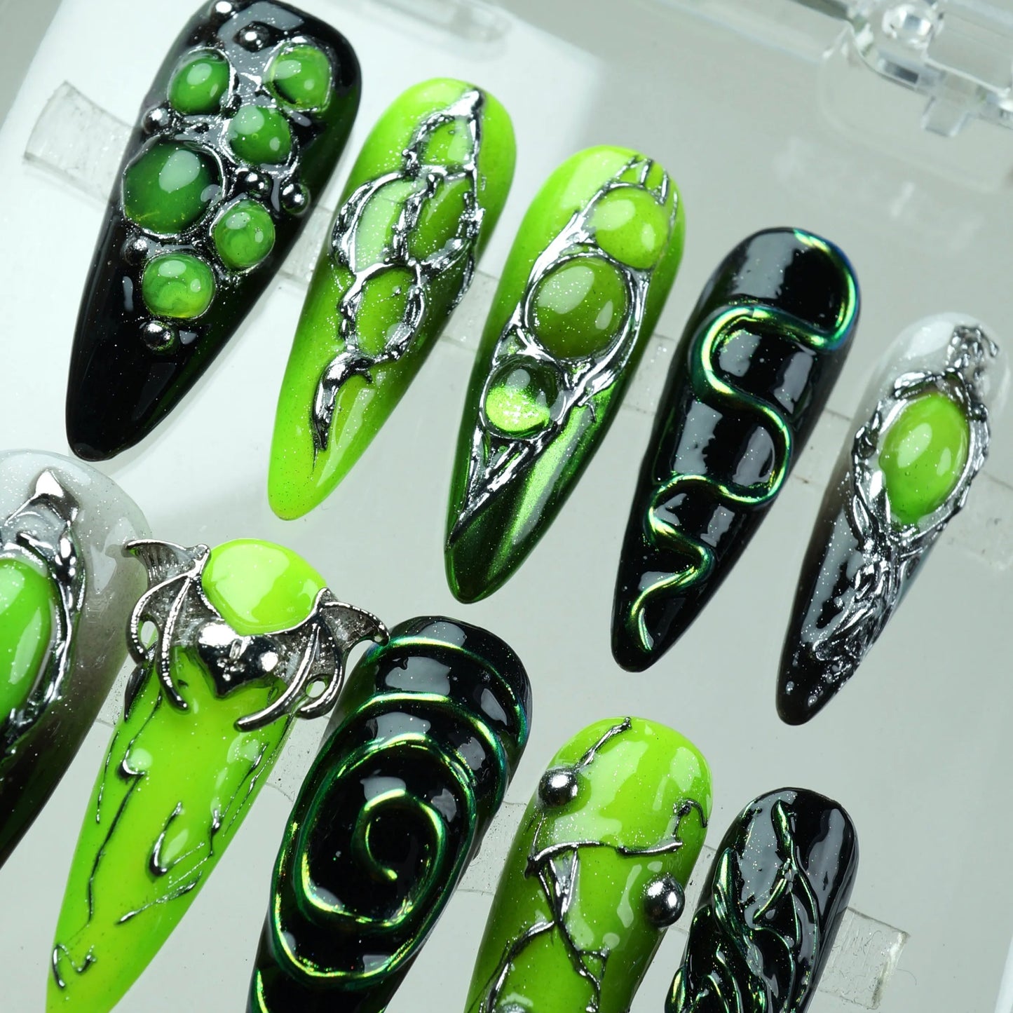 Neon green press-on nails with black chrome accents, spiked textures, and futuristic edge