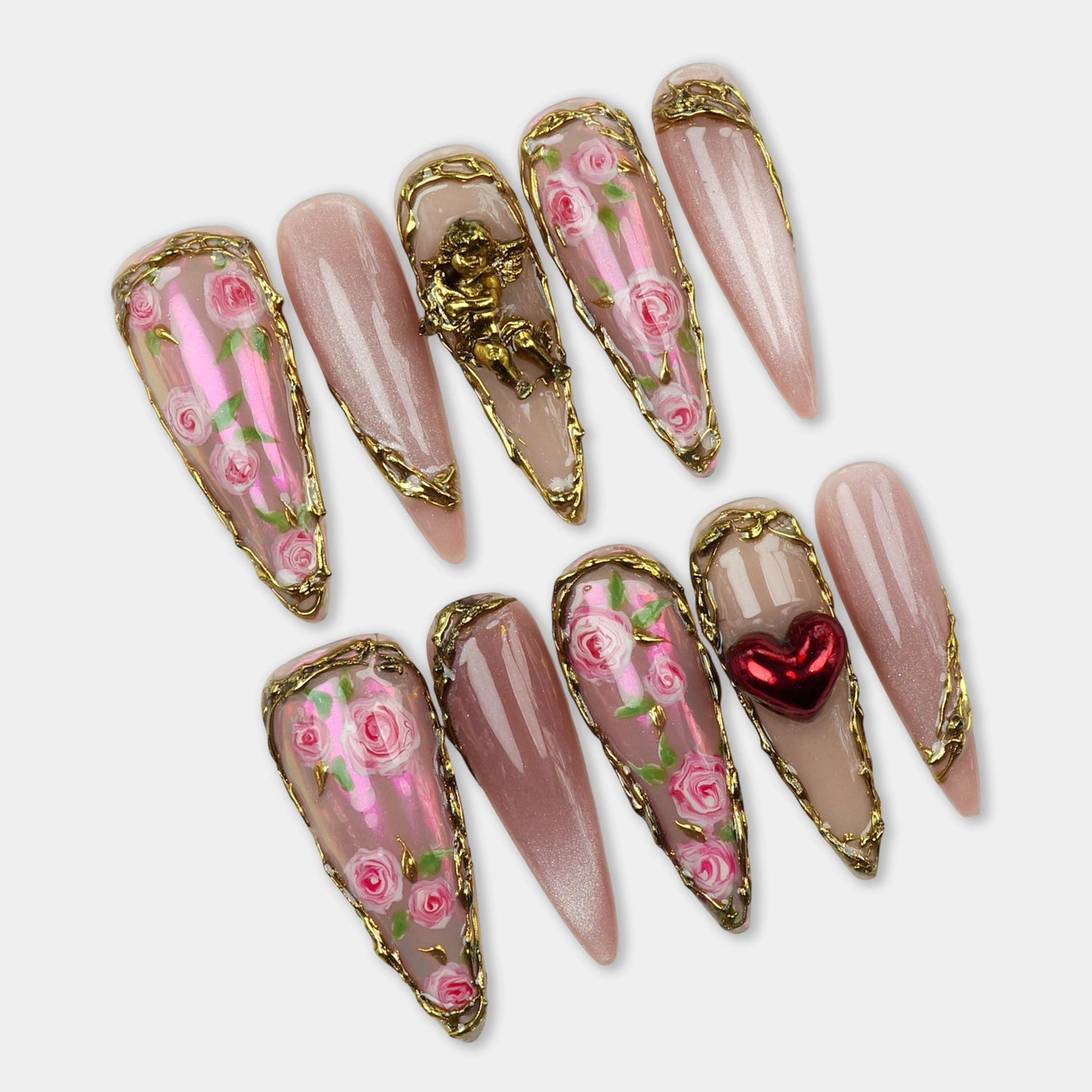 Elegant press-on nails with hand-painted pink roses, gold metal borders, and 3D details like a heart and cherub.