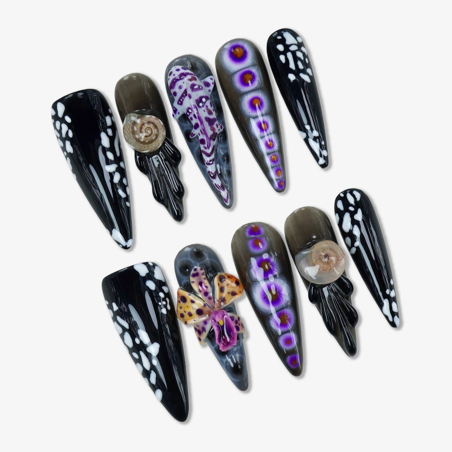Bold summer nails inspired by marine creatures, featuring 3D octopus, seashells, and striking black and purple patterns.