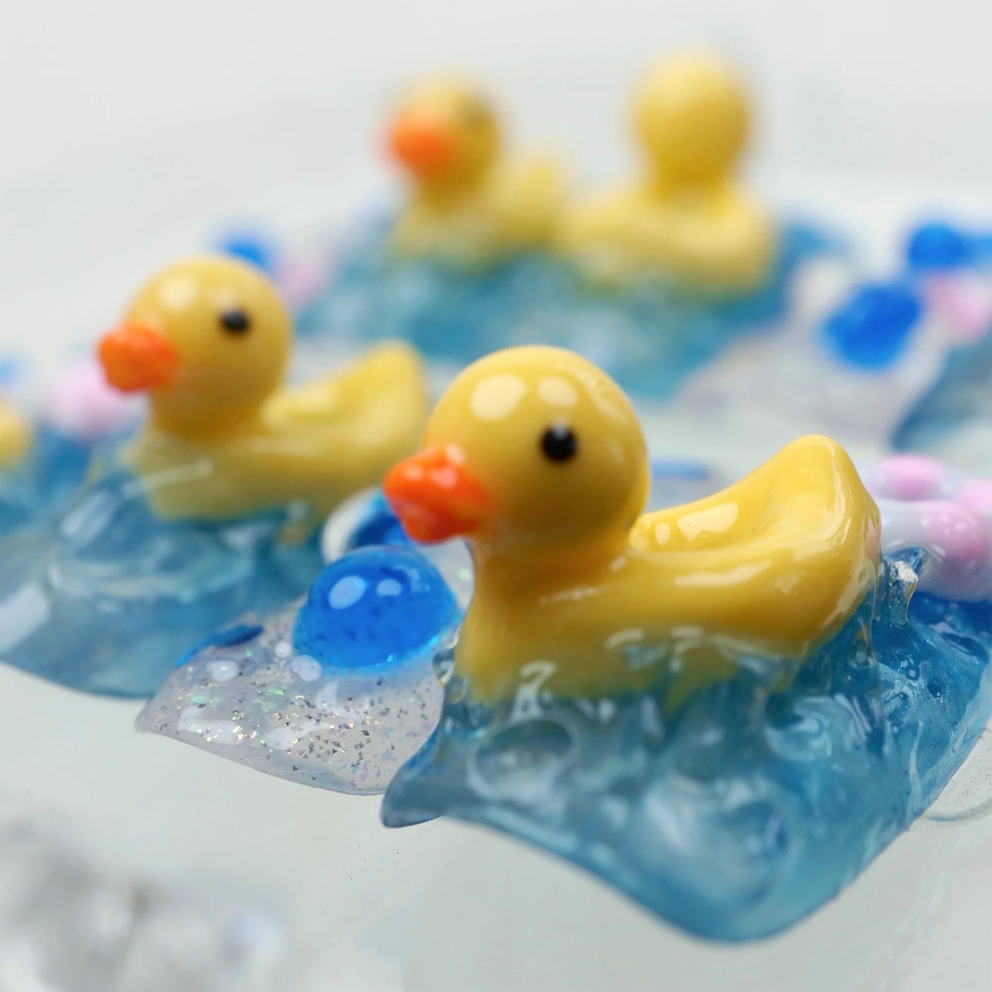 Playful funny nail art set with blue water textures, glitter accents, and tiny 3D duck figures