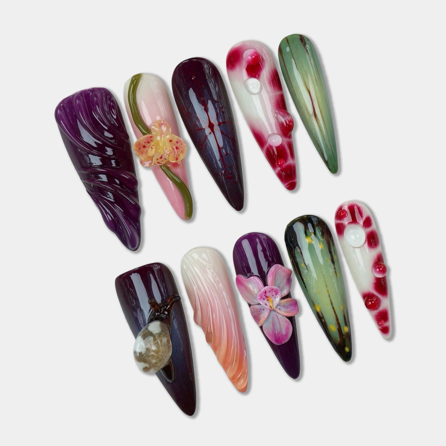Tropical flower design nails with deep purple and green tones, featuring 3D florals, glossy finishes, and shell accents