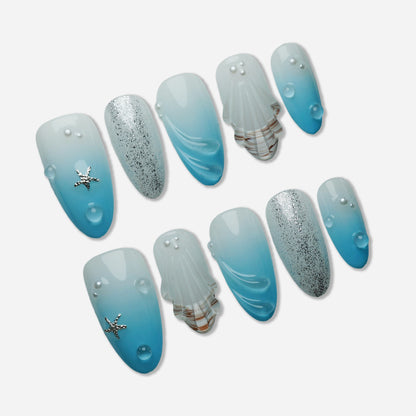 A30 | Blue Lagoon press-on nail set by Donailsart – soft blue gradient nails with translucent layers, sculpted shell textures, water droplet details, and subtle shimmer