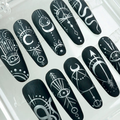 Mystic black press-on nails with fine white occult linework and celestial symbols
