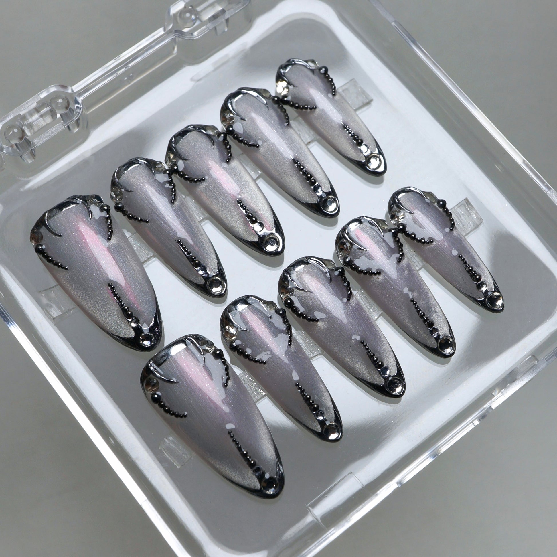 Chrome silver press-on nails with black gothic accents and delicate dot patterns for a sleek futuristic look.