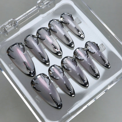 Chrome silver press-on nails with black gothic accents and delicate dot patterns for a sleek futuristic look.
