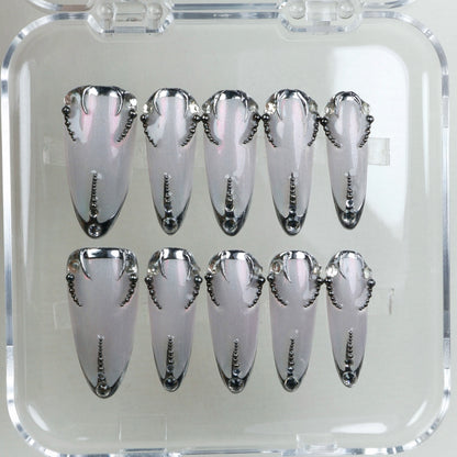 Pearl-silver press-on nails with sculpted black chrome tips and a dotted spine – classy with a dark twist.
