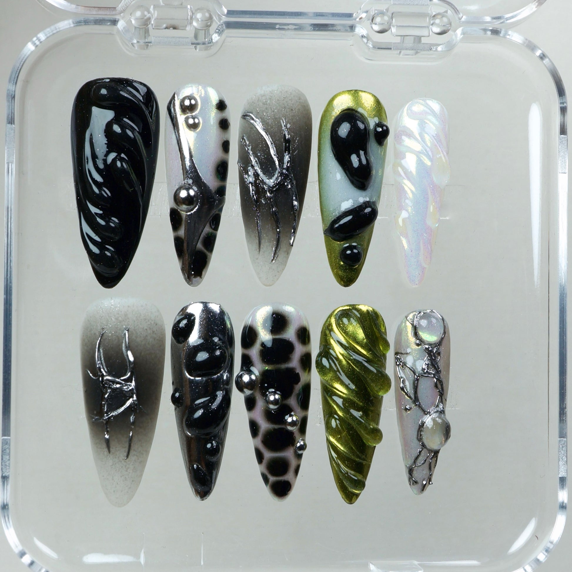 A high-concept nail set combining iridescent finishes, surreal textures, and sculptural chrome accents.