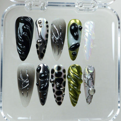 A high-concept nail set combining iridescent finishes, surreal textures, and sculptural chrome accents.