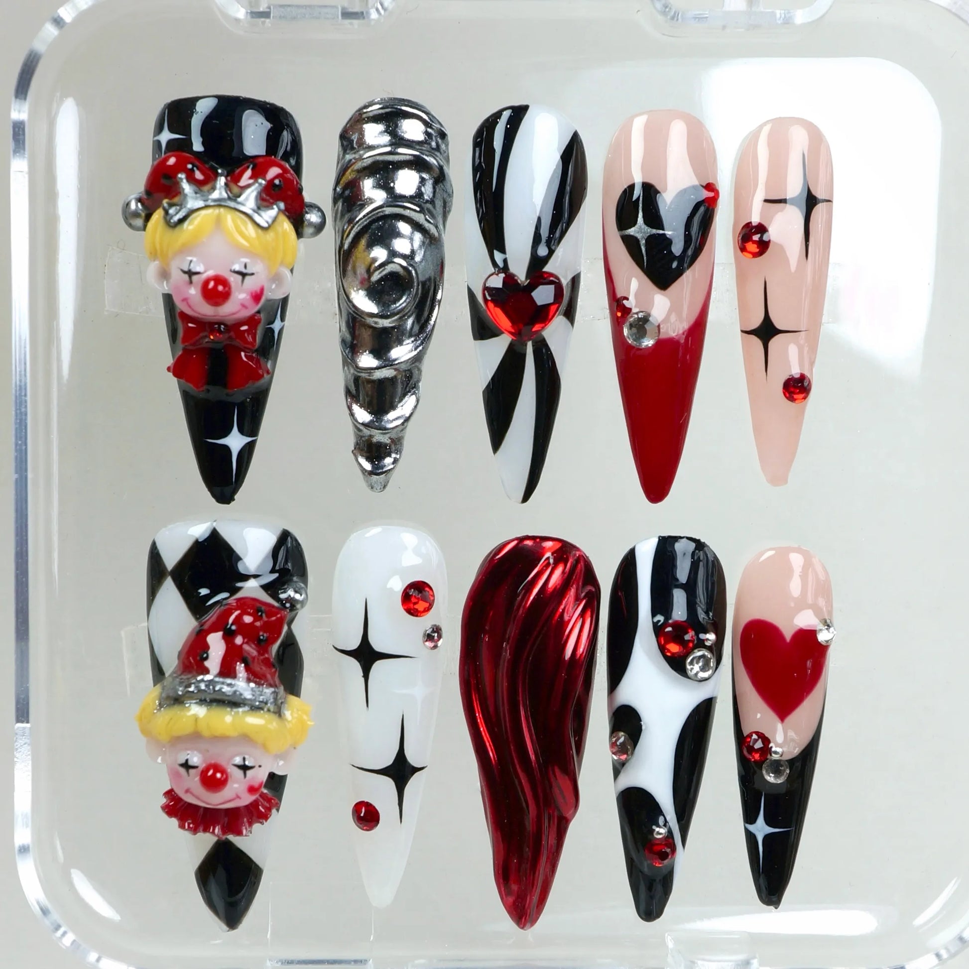Whimsical clown nails from Donailsart with circus vibes, heart motifs, and 3D face details in carnival colors.