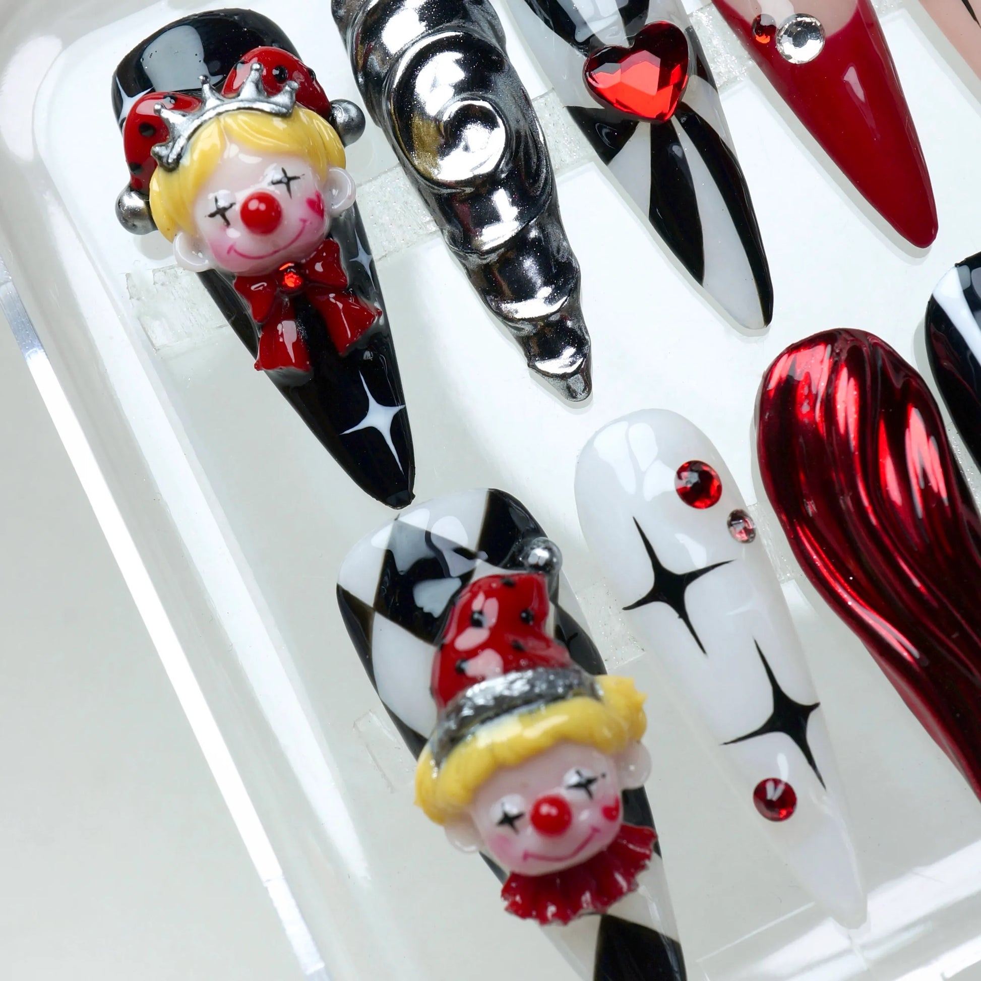 Clown nails with 3D elements, heart tips, and red rhinestones – handcrafted by Donailsart.